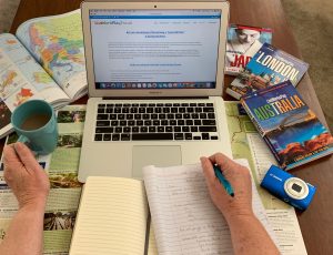 Laptop Of A Travel Writer Blogger With Books And A Coffee Cup.